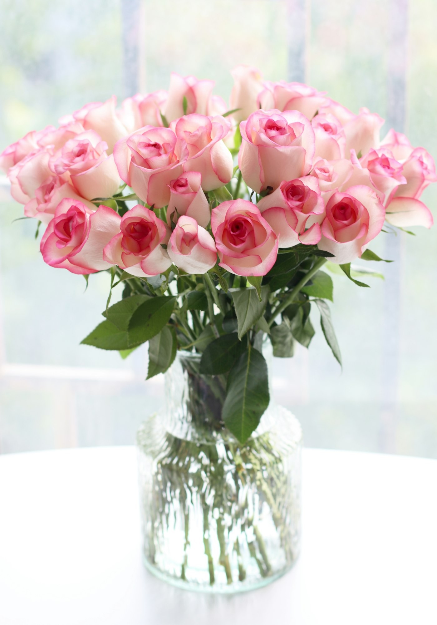 Pink and cream roses in a glass vase